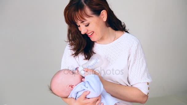 Mamá está alimentando al bebé con leche de un biberón de amor — Vídeos de Stock