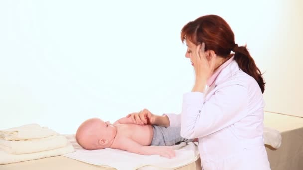 Доктор делает развивающий массаж малыша — стоковое видео