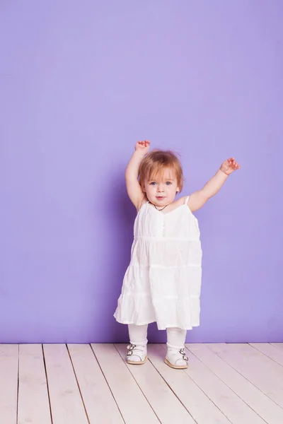 Bambina vestita di bianco su sfondo viola — Foto Stock