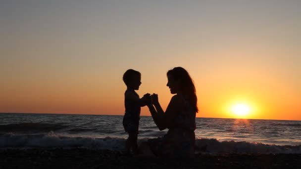 Silueta de mamá e hijo en Sunset Beach mar océano — Vídeos de Stock