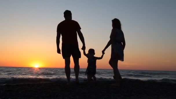 Familjen siluett i solnedgången nära havet mamma pappa barn — Stockvideo