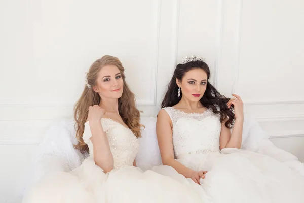 Portrét dvou mladých žen v svatební šaty v bílé hale — Stock fotografie