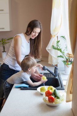 küçük çocuk anne mutfakta yardımcı oluyor