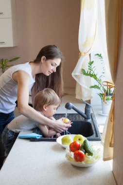 küçük çocuk anne mutfakta yardımcı oluyor