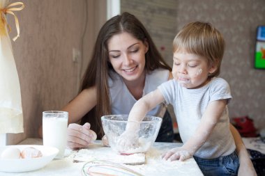 Anne ve genç oğlu mutfakta bir pasta hazırlamak