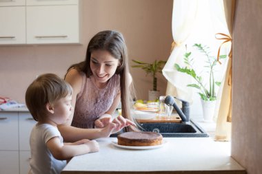 Anne ve oğul mutfakta pasta yemek