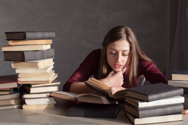 Kız okuma kitabı kütüphanede sınava hazırlar