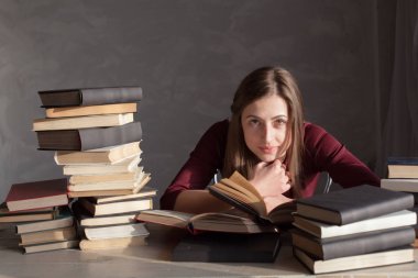 Kız okuma kitabı kütüphanede sınava hazırlar