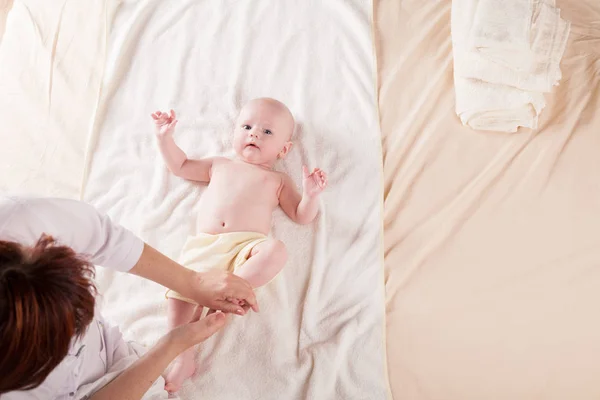 Мать маленького мальчика делает массаж рук и ног — стоковое фото