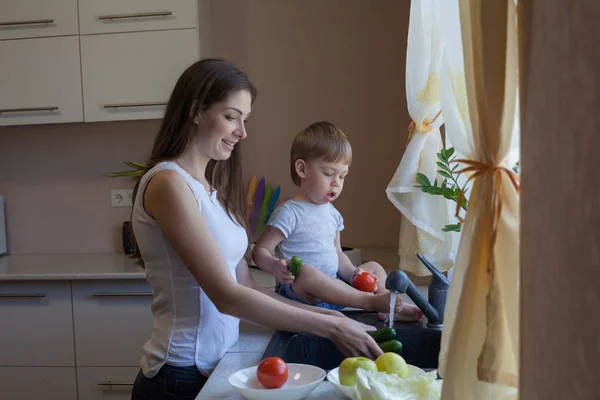 Кухня мама син миє фрукти та овочі — стокове фото