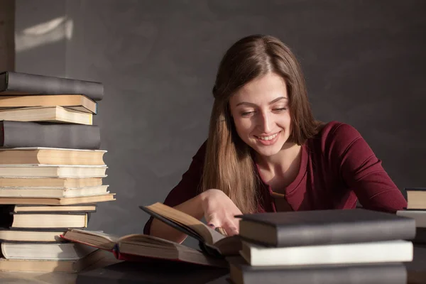 Menina lê um monte de livros em casa — Fotografia de Stock