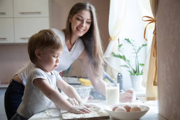 Mutter und kleiner Sohn bereiten Kuchen in der Küche zu — Stockfoto