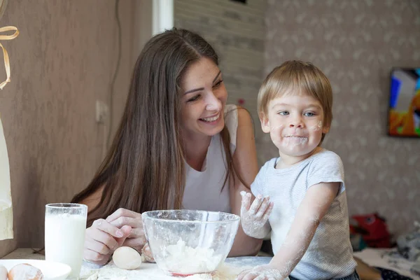 Anne ve genç oğlu mutfakta bir pasta hazırlamak