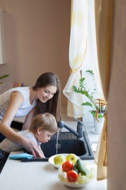 küçük çocuk anne mutfakta yardımcı oluyor