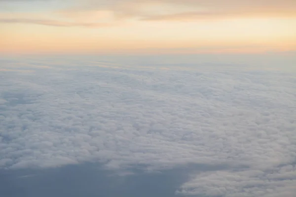 Sobrevolando las nubes al atardecer desde un avión — Foto de Stock