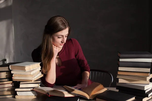 Девушка, читающая книгу в библиотеке готовится к экзамену — стоковое фото