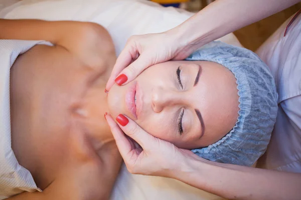Medico cosmetologo facendo massaggio facciale ragazza Spa — Foto Stock