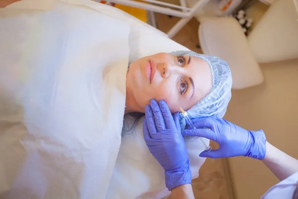 Medico estetista aumenta labbro paziente una siringa per iniezione — Foto Stock