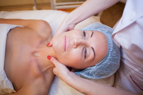 Medico cosmetologo facendo massaggio facciale ragazza Spa — Foto Stock