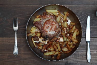 bir tablo üzerinde et ve patates tava ile akşam yemeği kızarmış