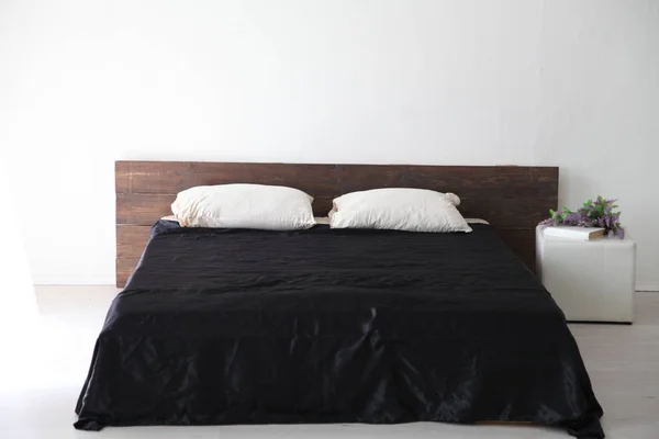 Інтер'єр білої спальні і ліжка з чорними листами — стокове фото