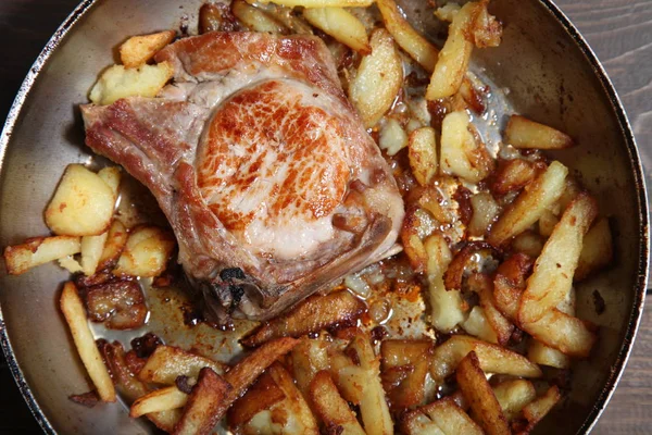 bir tablo üzerinde et ve patates tava ile akşam yemeği kızarmış