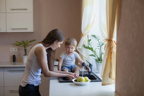 Küche Mutter Sohn waschen Obst und Gemüse — Stockfoto