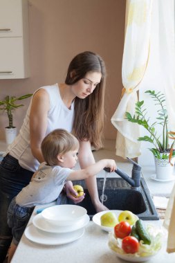 küçük çocuk anne mutfakta yardımcı oluyor
