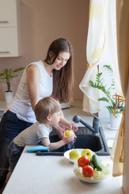 küçük çocuk anne mutfakta yardımcı oluyor
