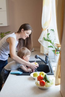 küçük çocuk anne mutfakta yardımcı oluyor