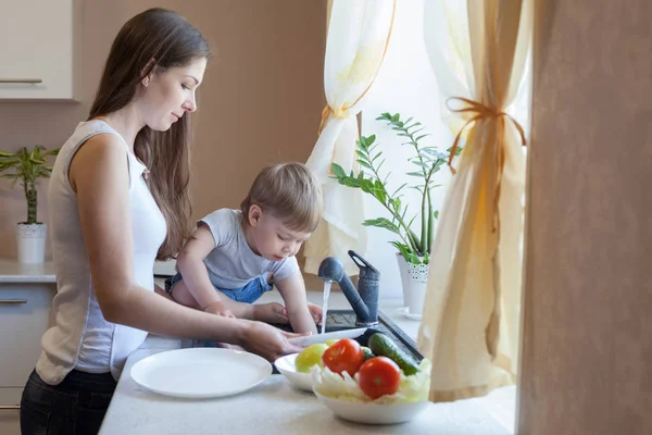 Der kleine Junge hilft Mama in der Küche — Stockfoto