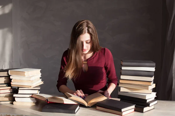 Menina lendo um livro na biblioteca está se preparando para o exame — Fotografia de Stock