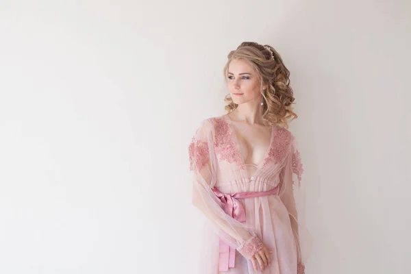 Menina bonita em lingerie rosa fica em paredes brancas — Fotografia de Stock