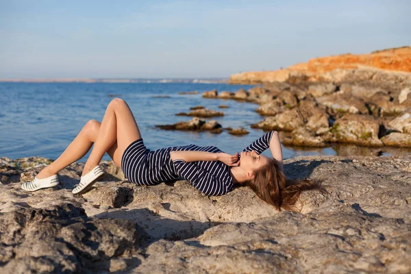 Girl lies on her back on a stone Beach — Stock Photo, Image