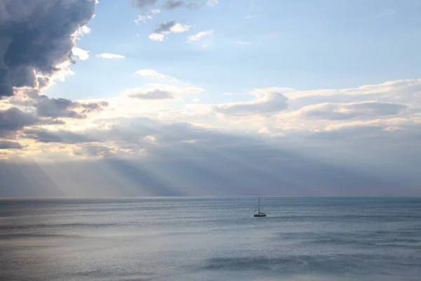Yate en el mar rayos de nubes paisaje — Foto de Stock