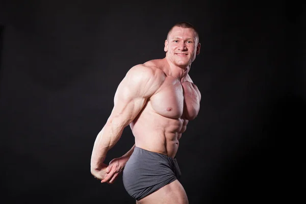 A sportoló testépítő mutatja az izmait, sportolás után — Stock Fotó