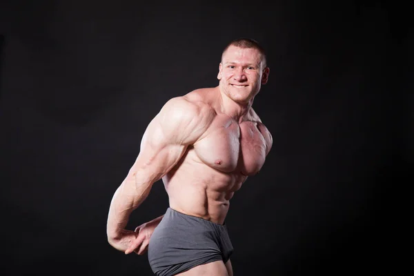 Kulturista sportovec ukazuje své svaly po sportu — Stock fotografie