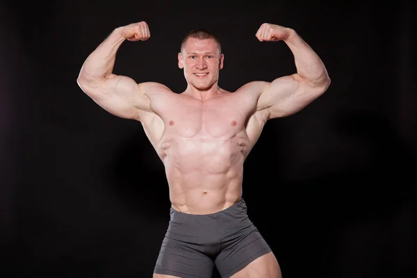 De atleet bodybuilder pronkt met zijn spieren sport — Stockfoto