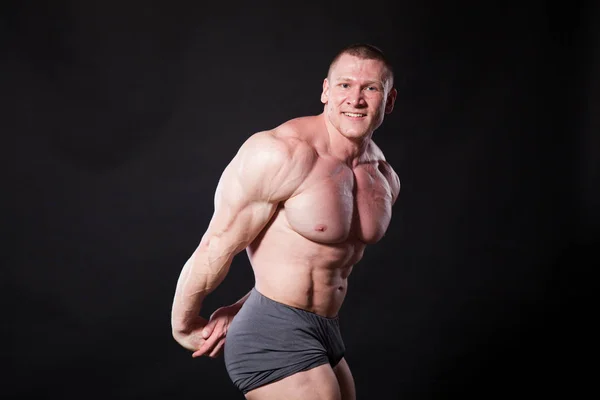 A sportoló testépítő mutatja az izmait, sportolás után — Stock Fotó