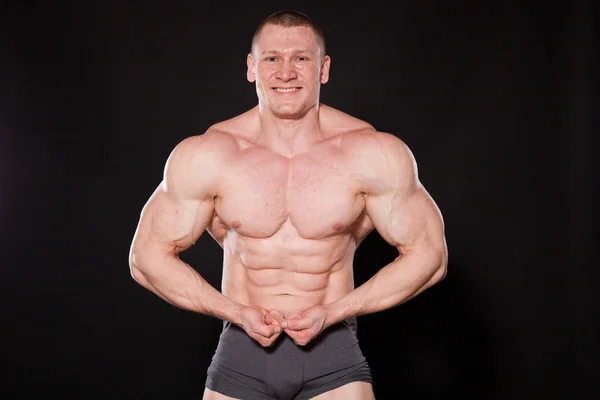Спортсмен бодібілдер показує свої м'язи після спорту — стокове фото