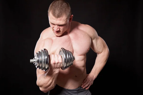 Sport l'atleta bodybuilder costruire manubri muscolari — Foto Stock