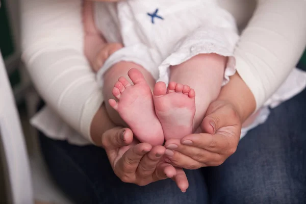 Mamá y papá están sosteniendo las piernas del bebé —  Fotos de Stock