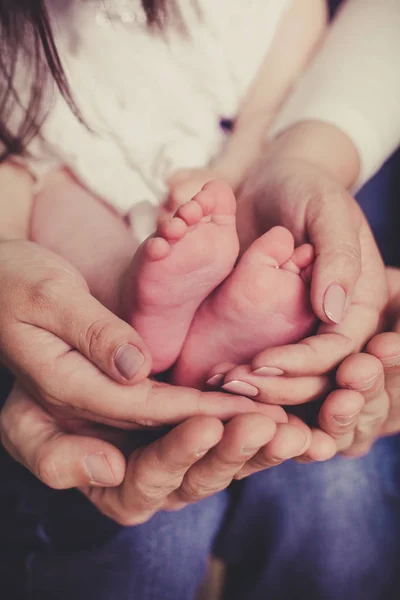 Mamma og pappa holder babybein. – stockfoto