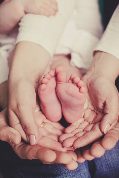 Mamá y papá están sosteniendo las piernas del bebé —  Fotos de Stock