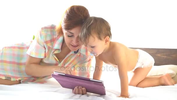 母亲和年幼的儿子很喜欢这款平板电脑在互联网上的卧室里 — 图库视频影像