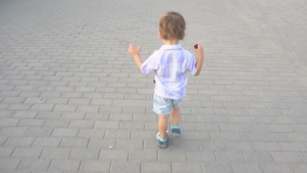 Pequeño niño corre en el camino — Vídeo de stock