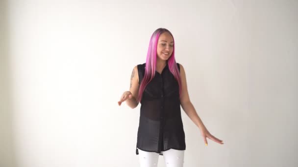 Lány pózol egy fehér szobában rózsaszín hajjal — Stock videók