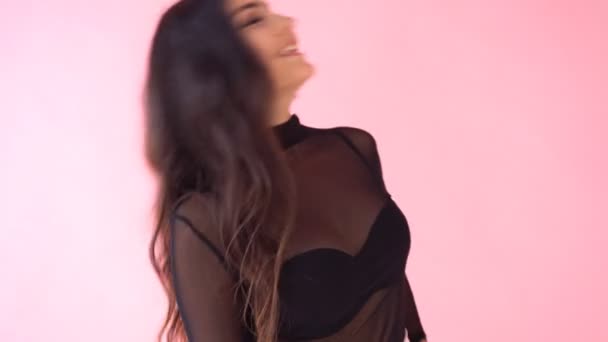 Брюнетка девушка позирует на розовом фоне улыбка эмоций — стоковое видео