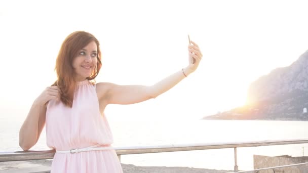 En flicka tar bilder på sig själva på telefonen på semester — Stockvideo