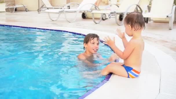 Dos chicos hermano bañarse en la piscina en el complejo — Vídeo de stock